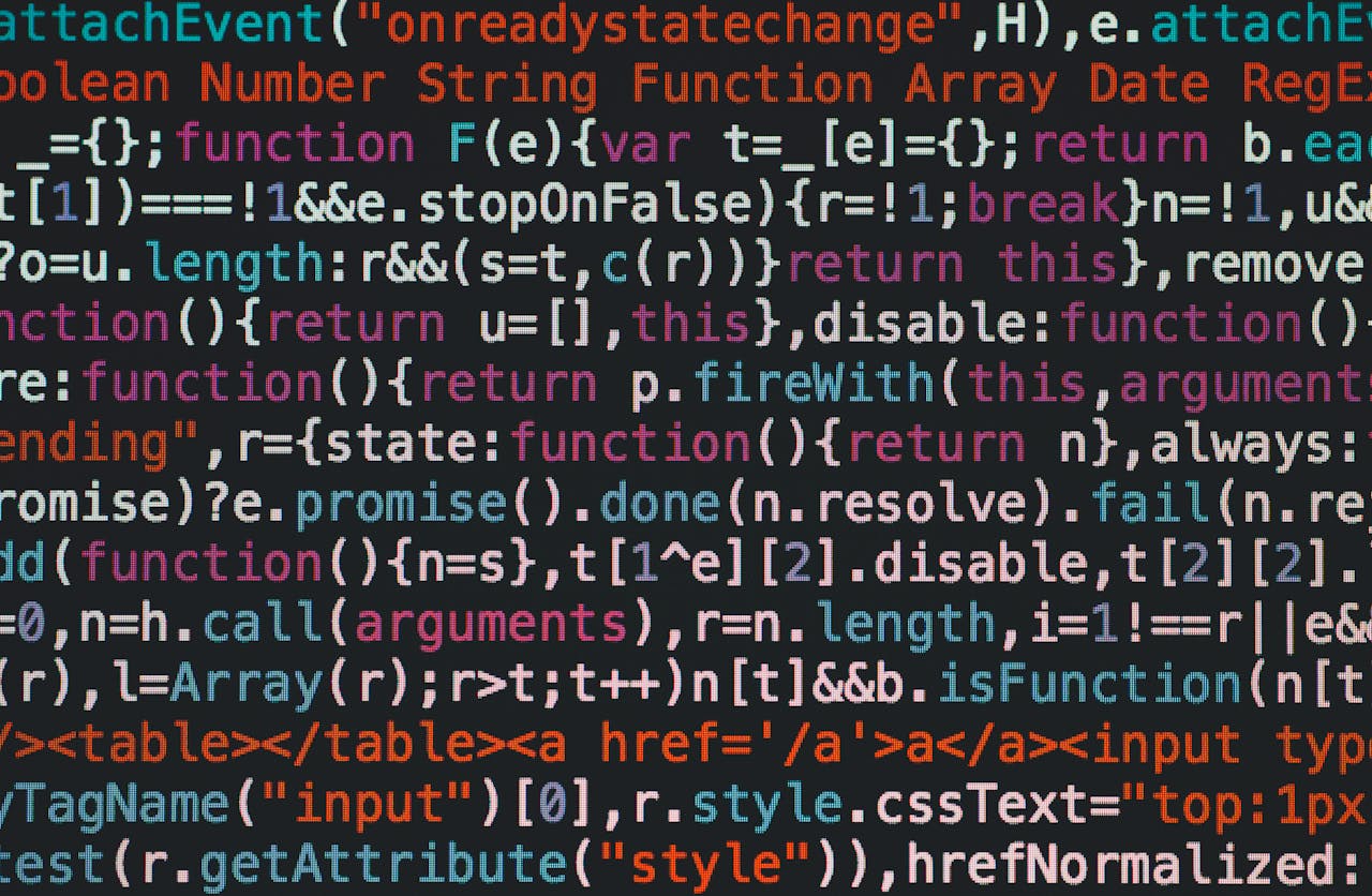 about-us-02 Close-up of colorful coding text on a dark computer screen, representing software development.